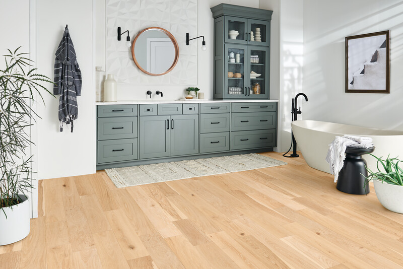 Bathroom with a long vanity and tub to the side with light waterproof hardwood floors