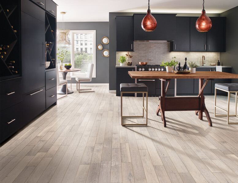 Kitchen with dark cabinets and an island seating area with light hardwood floors